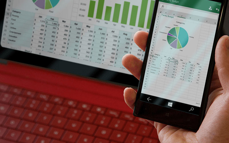 Hand holding a smart phone displaying financial charts