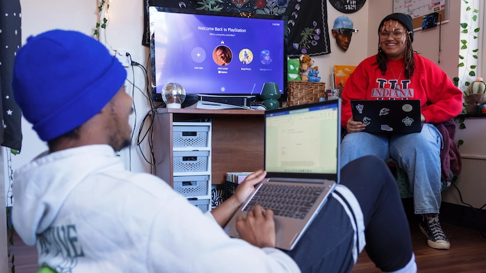 Students talking to each other while using laptops