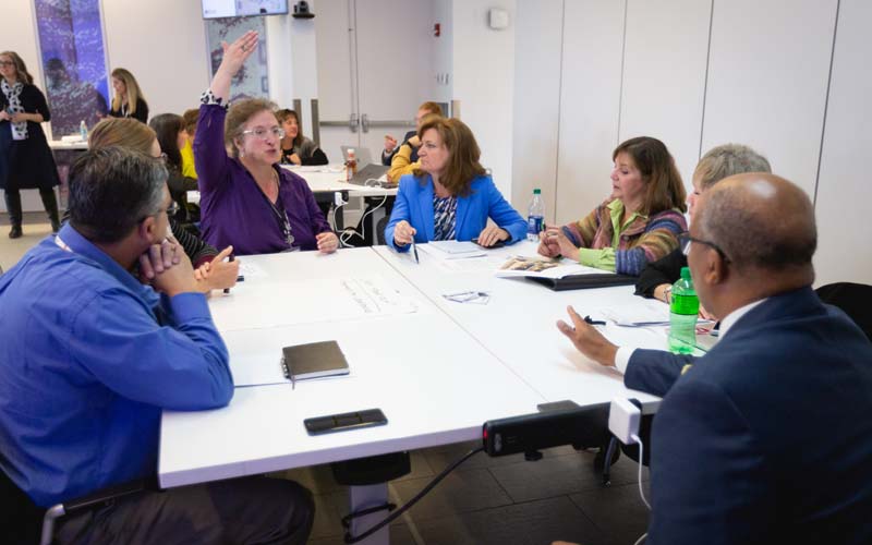 Mosaic Faculty Fellows collaborating around a table in an active learning classroom